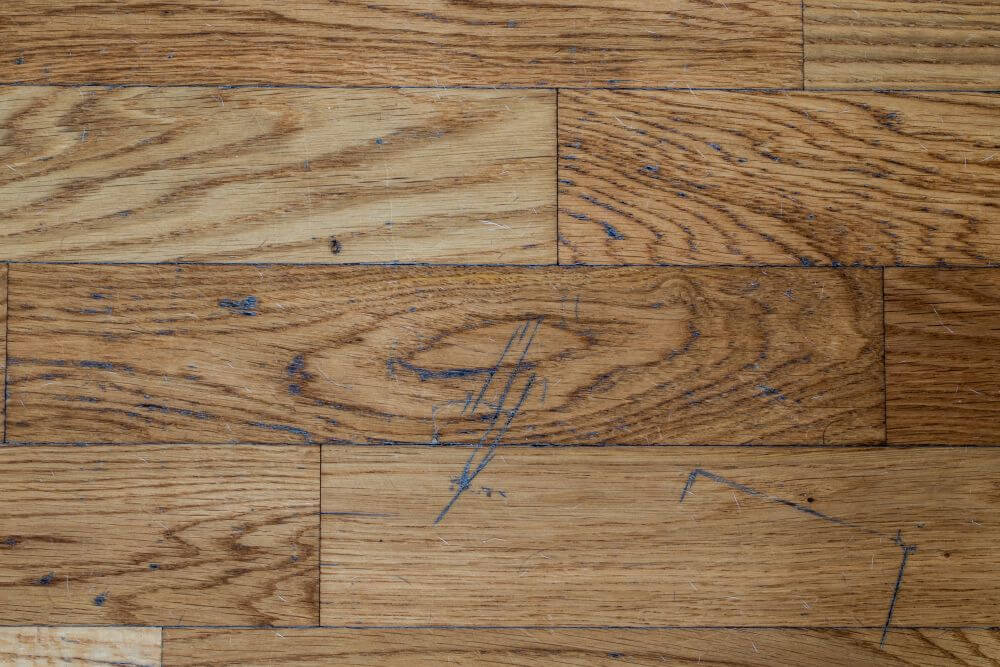 graffi su un parquet in rovere verniciato